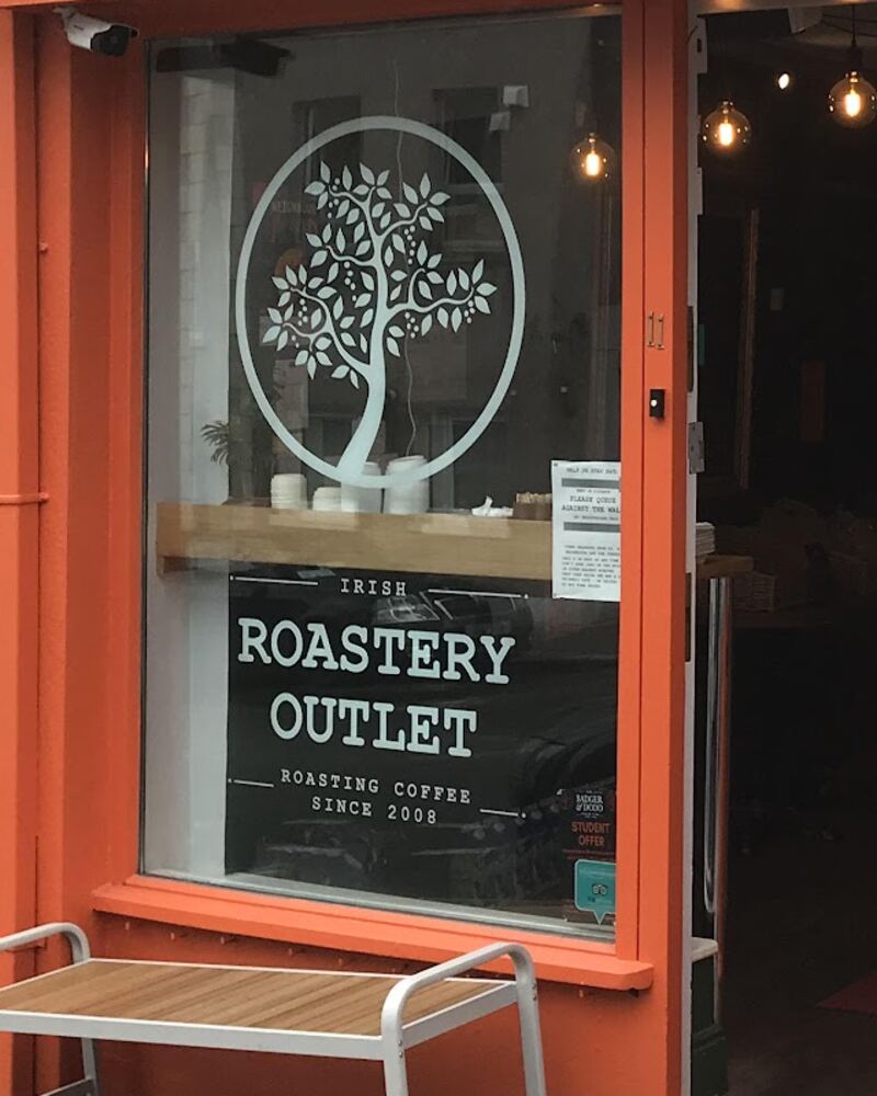 The window of the Barrack St outlet with the tree logo and the Irish Roastery Outlet, roasting coffee since 2008, vinyl